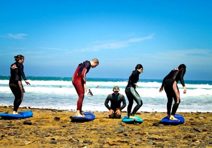 Surfing course students with instructor in lanzarote coast