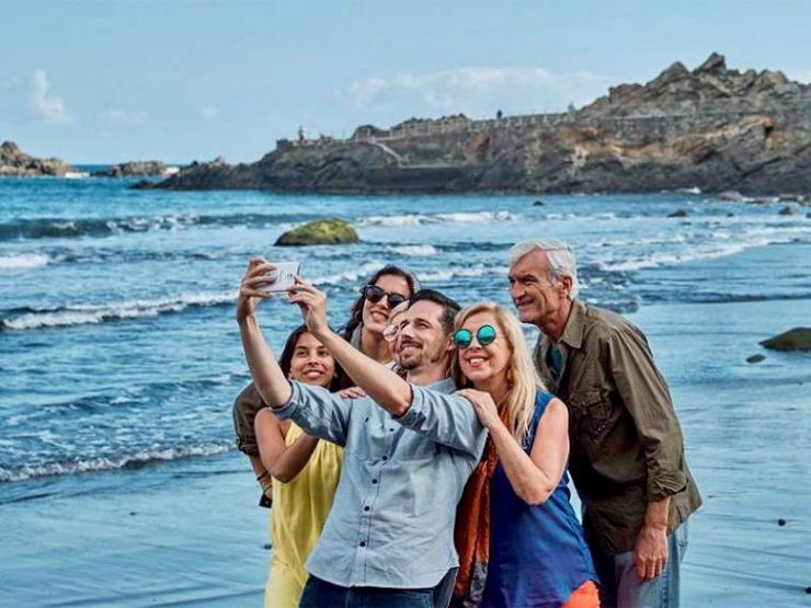 Happy family taking a selfie photo on the beach