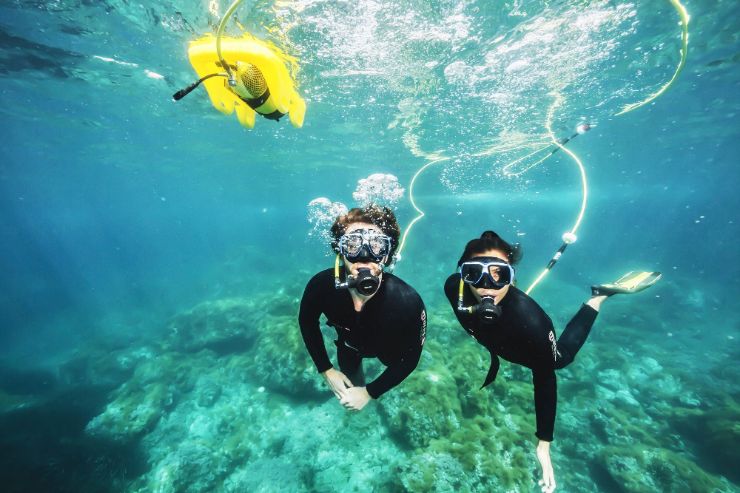 Couple enjoying underwater scuba snorkel in Lobos island